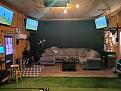Couch, other TVs, bar and fridge.