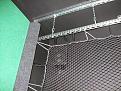 Closer view of backing net install. Left screen baffle is visible as carpet roll to left of net. The baffle hides the edge of the impact screen and supporting bungees