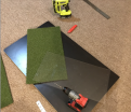 Lexan/Polycarbonate with holes drilled at each end, along with the 1' x 2' strip of Synlawn turf.